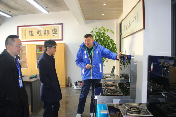 杏盛平台电器副总裁王春雷为沈建新教授一行人介绍杏盛平台·AIoT智能集成灶